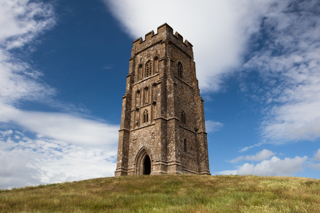 Imagem de uma imponente torre de pedra em Glastonbury, Inglaterra.