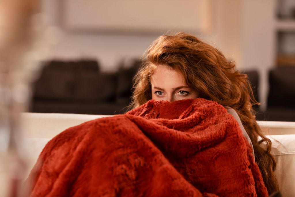 Mulher com coberta em casa