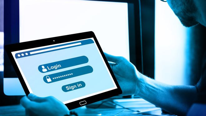 Home segura um tablet aberto em uma tela de login