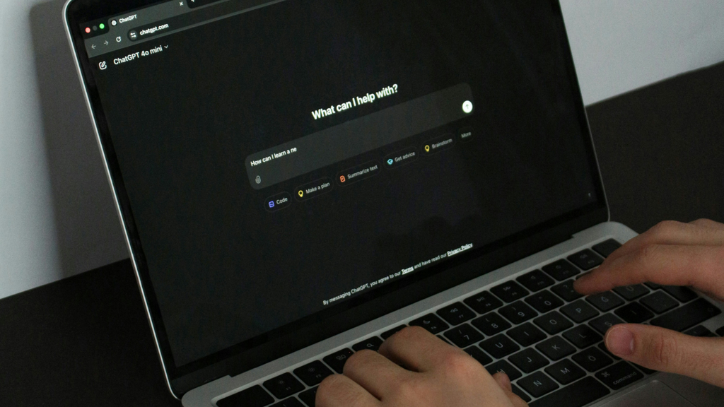Pessoa digitando em um notebook com o ChatGPT aberto