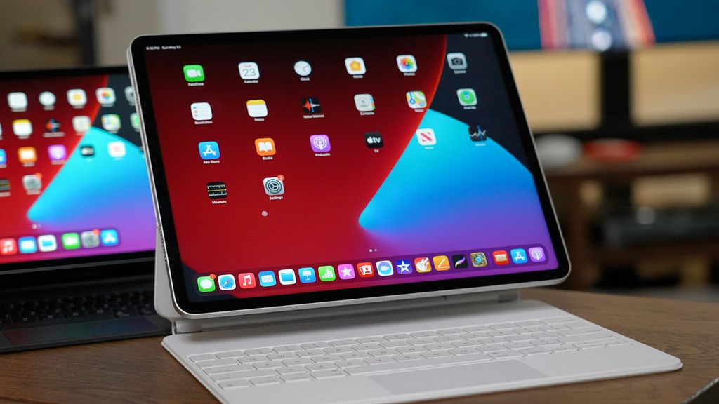 Tablet com capa com teclado branco e vários aplicativos na tela.