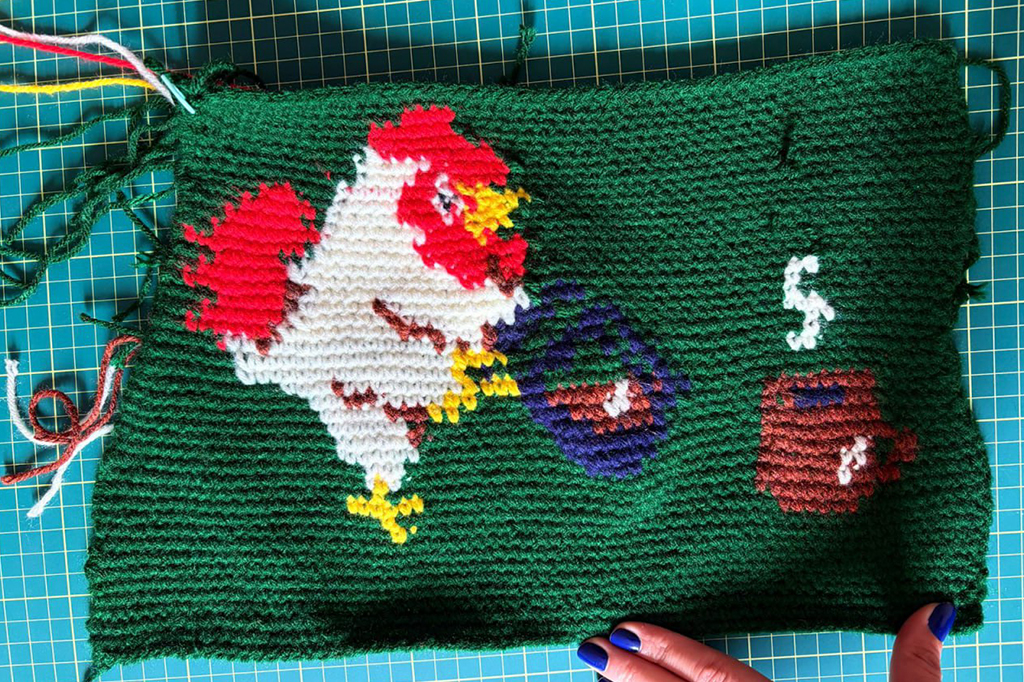 Fotografia da peça de crochê do galo servindo café.