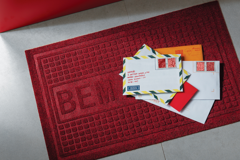 Imagem de diversos envelopes em cima de um tapete vermelho.