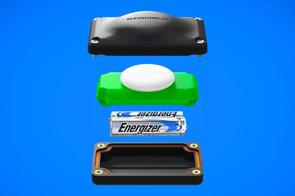 Componentes de um dispositivo ElevationLab: uma tampa preta com o nome da marca, um AirTag branco sobre uma base verde, duas pilhas Energizer Ultimate Lithium e a base inferior preta com borda laranja.