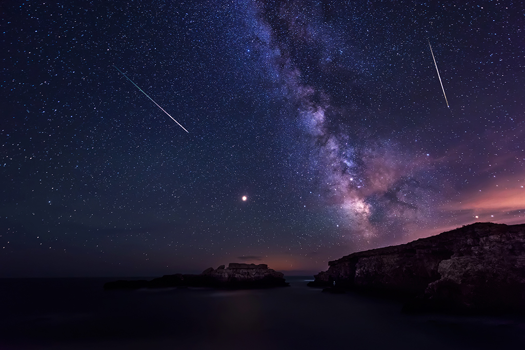 Foto de longa exposição mostrando a Via Láctea e as Perseidas.